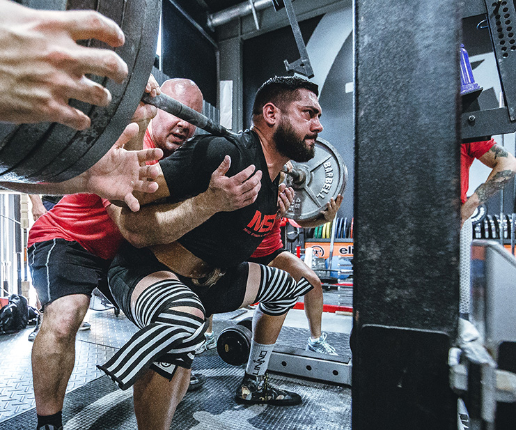 A Trainer spotting a weight lifter